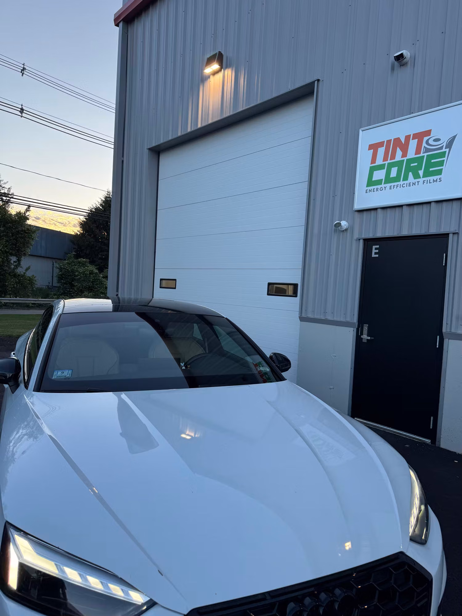 Close front view of a white sport sedan with dark tinted front and side glass after installation.