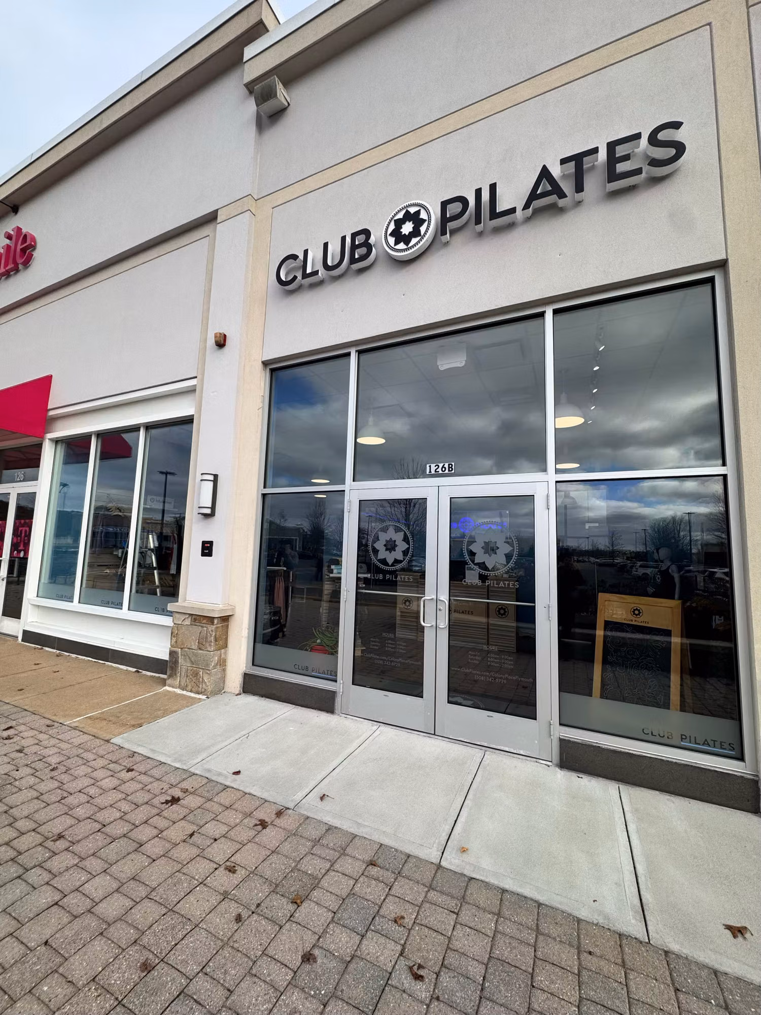 Exterior of a fitness studio storefront with frosted emblem graphics visible on the glass entry doors and windows.