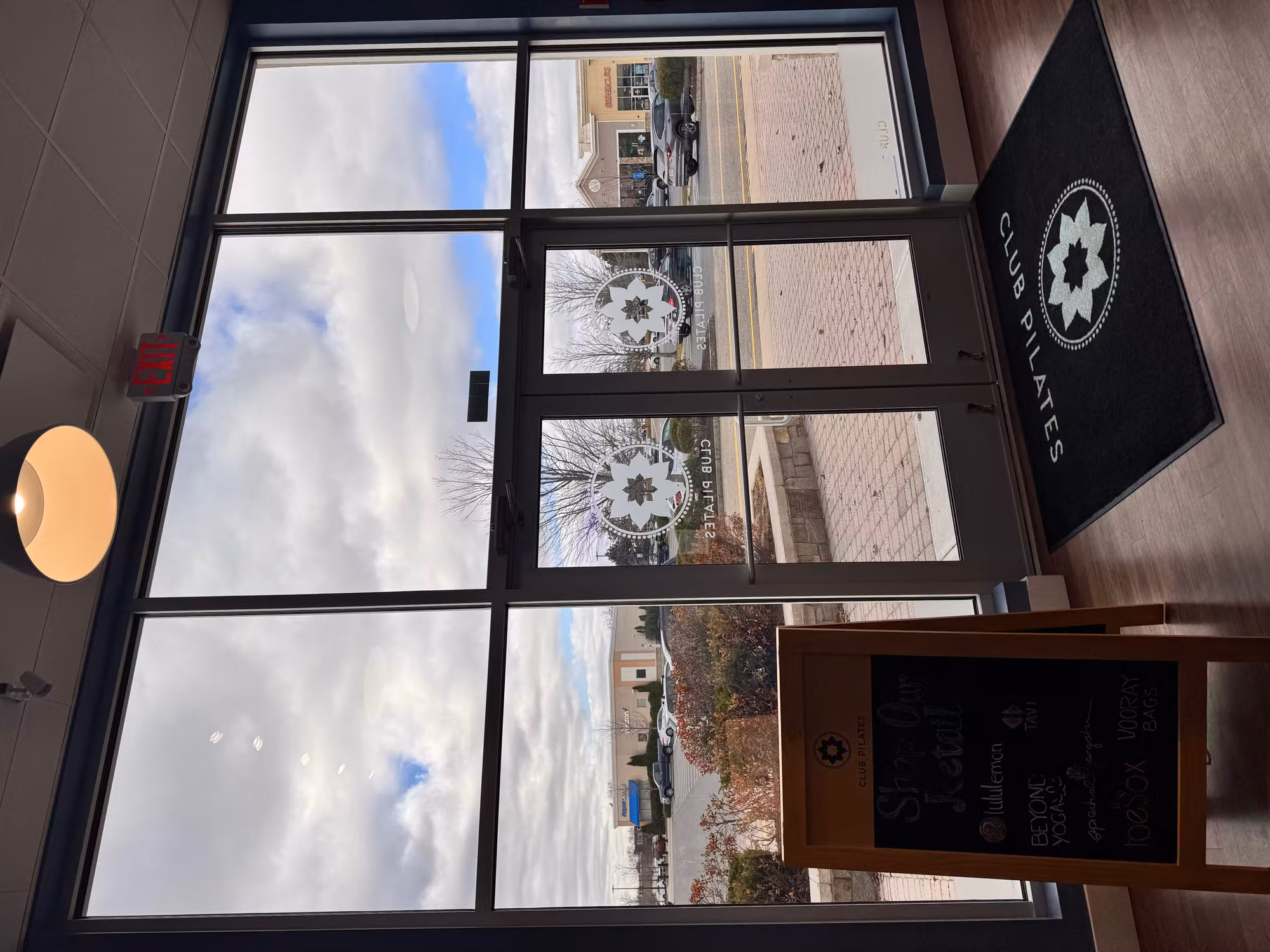 Frosted circular emblem graphics applied to clear glass entry doors and storefront windows of a studio interior.