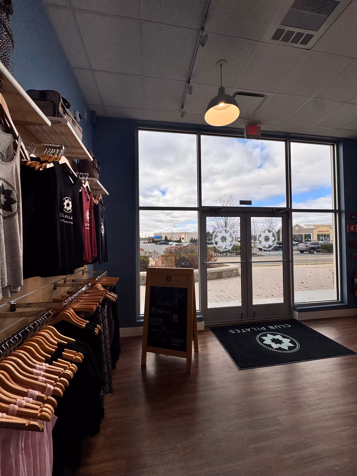 Interior view of a studio sales floor with frosted circular emblem graphics on the floor-to-ceiling storefront glass.