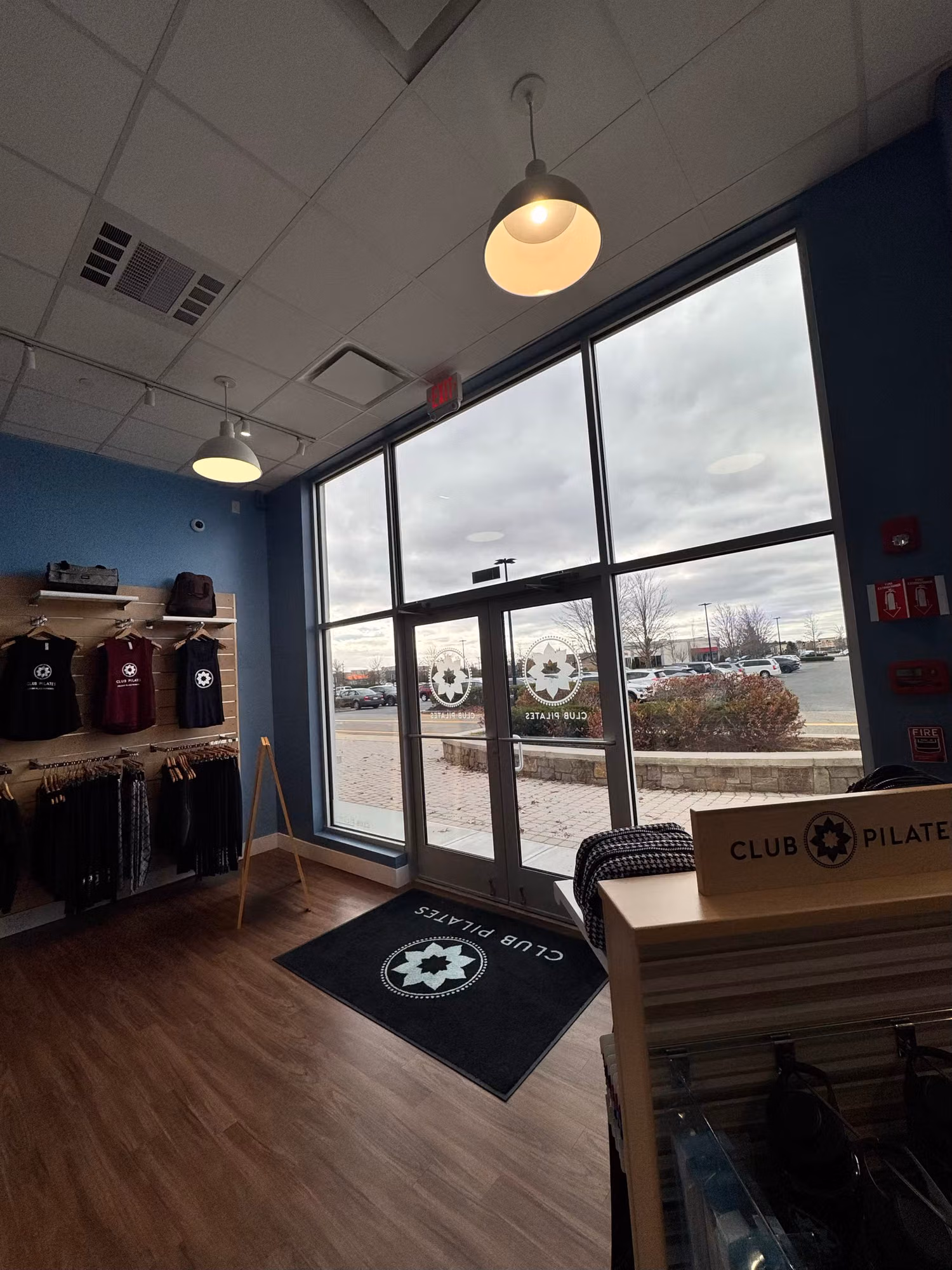 Studio interior showing frosted circular emblem graphics applied to the clear floor-to-ceiling storefront windows and doors.