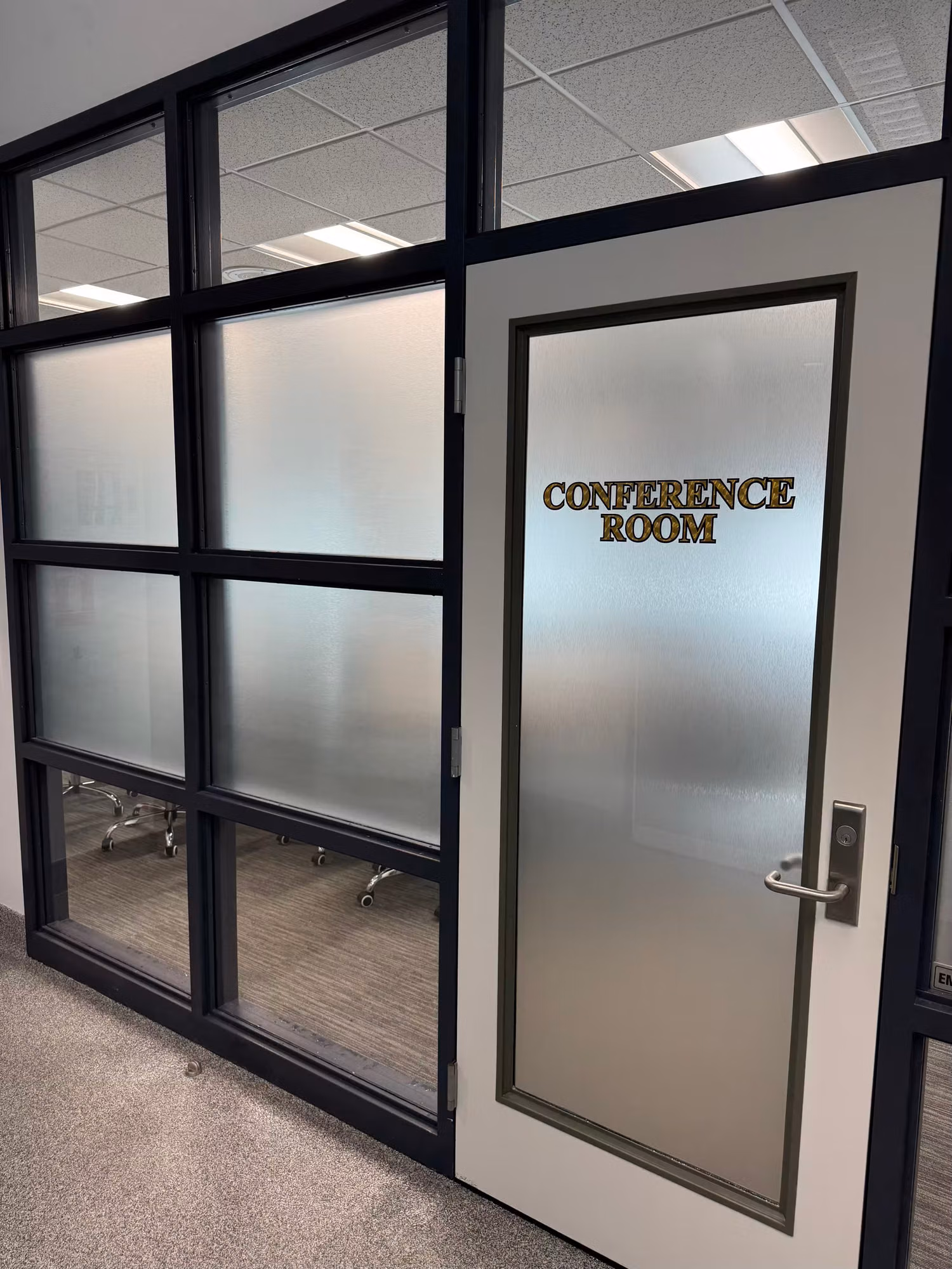 Glass-walled conference room with a frosted privacy band on the partition and a frosted door with Conference Room lettering.