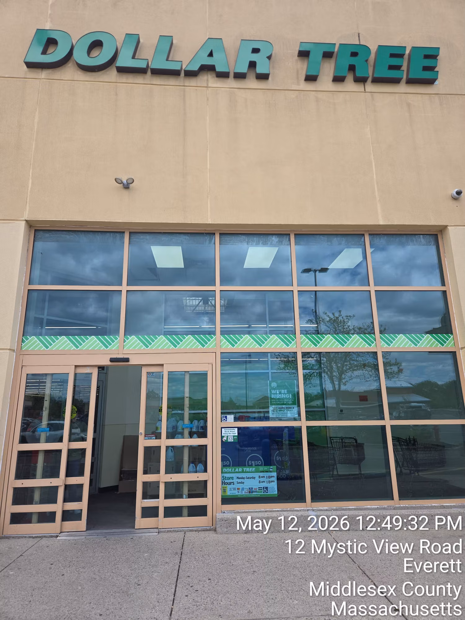 Retail storefront entrance with a decorative patterned film band running across the lower window glass.
