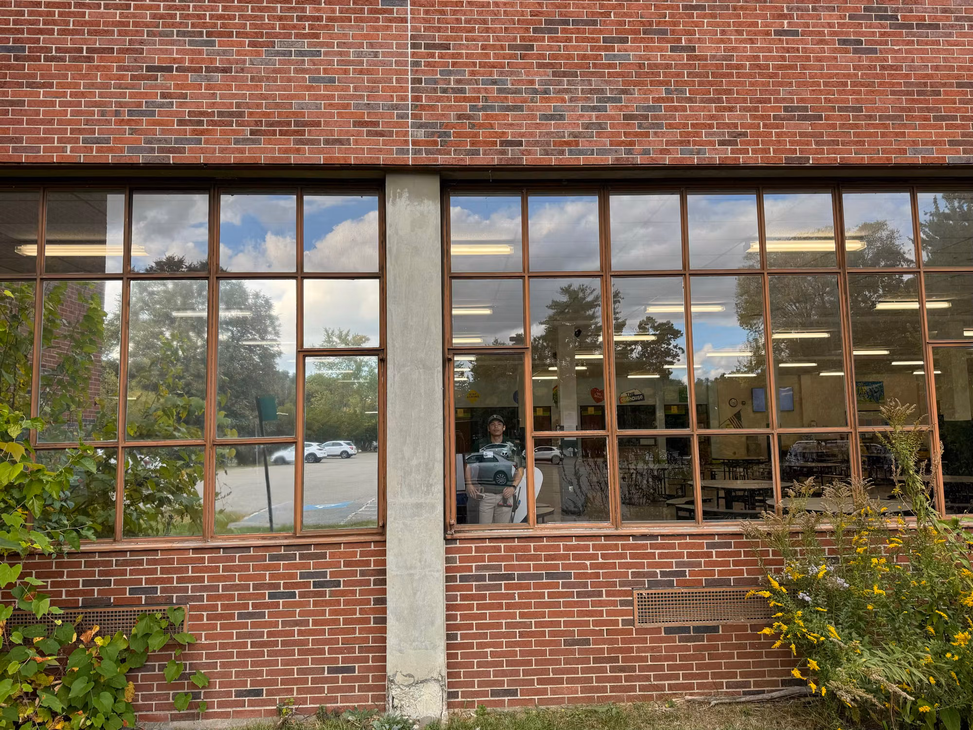 Wide exterior view of brick school cafeteria windows finished with reflective solar control film.