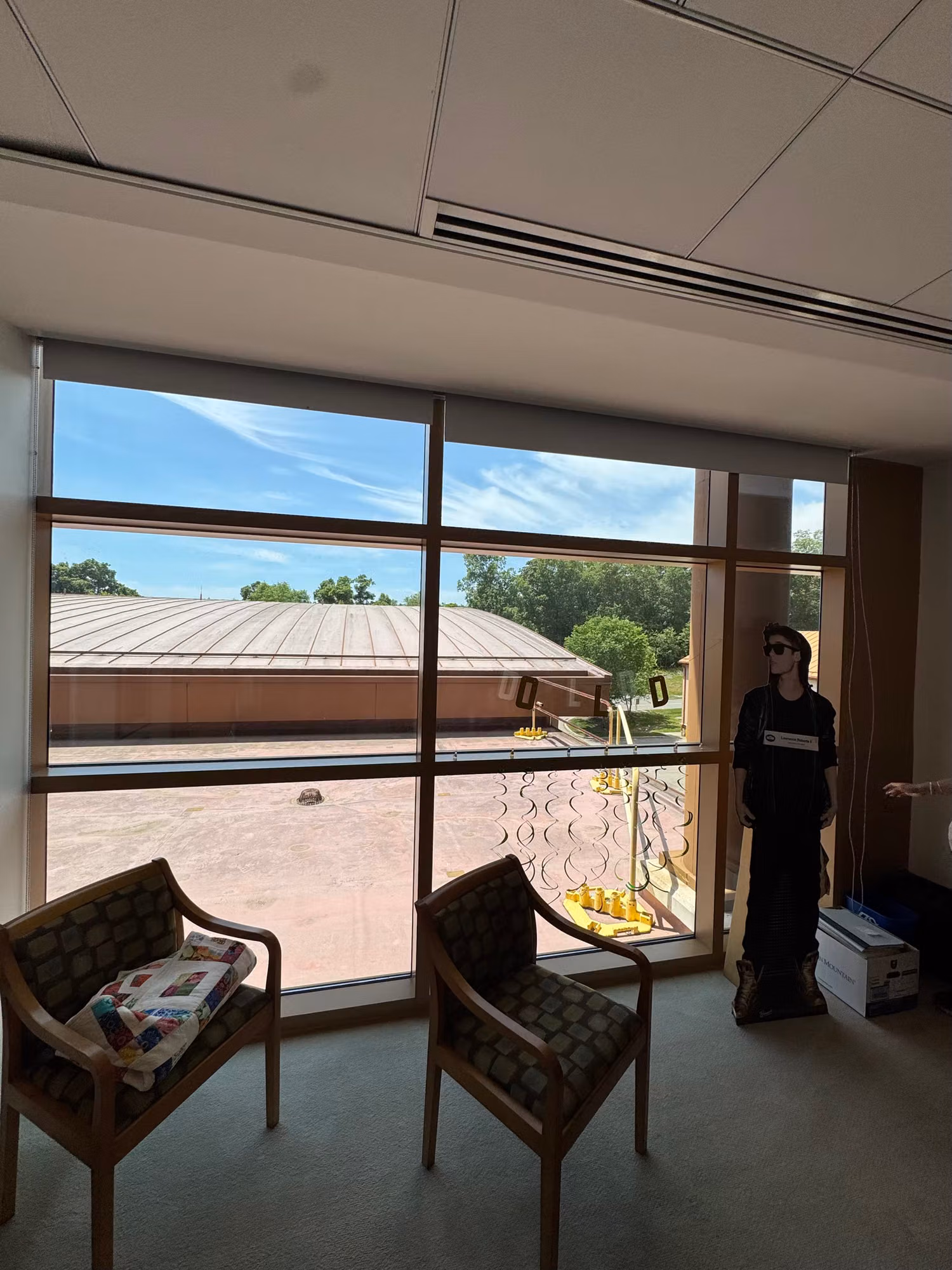Office window with a frosted dot-pattern privacy band on the lower glass while an installer works nearby.