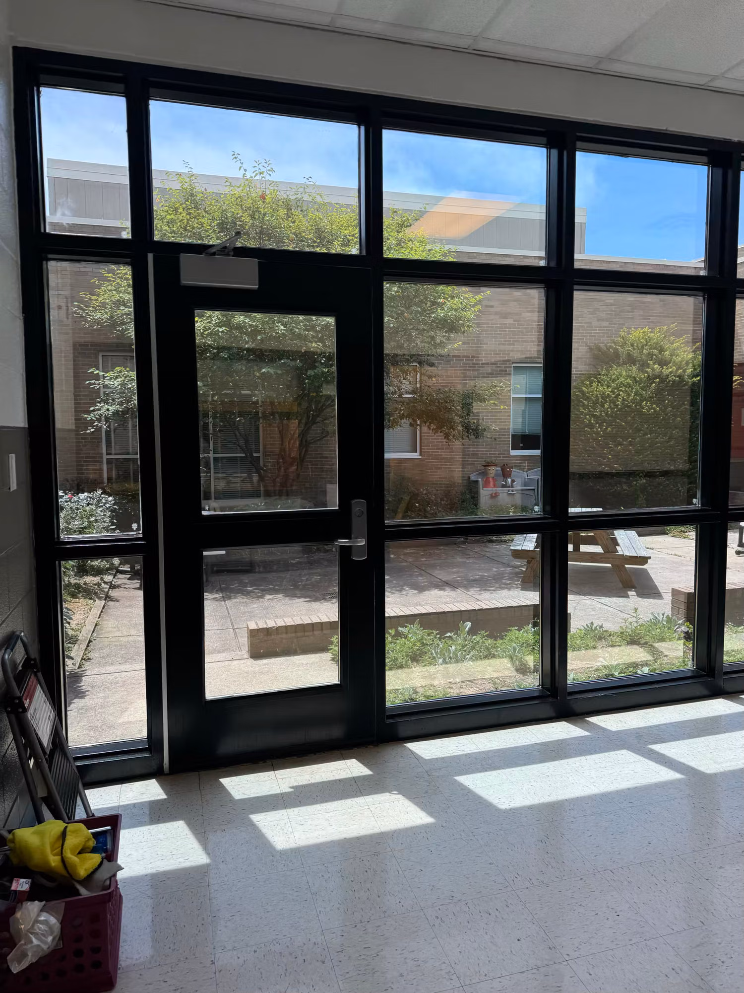 Interior glass entry doors with sidelights and a transom opening onto a planted courtyard.