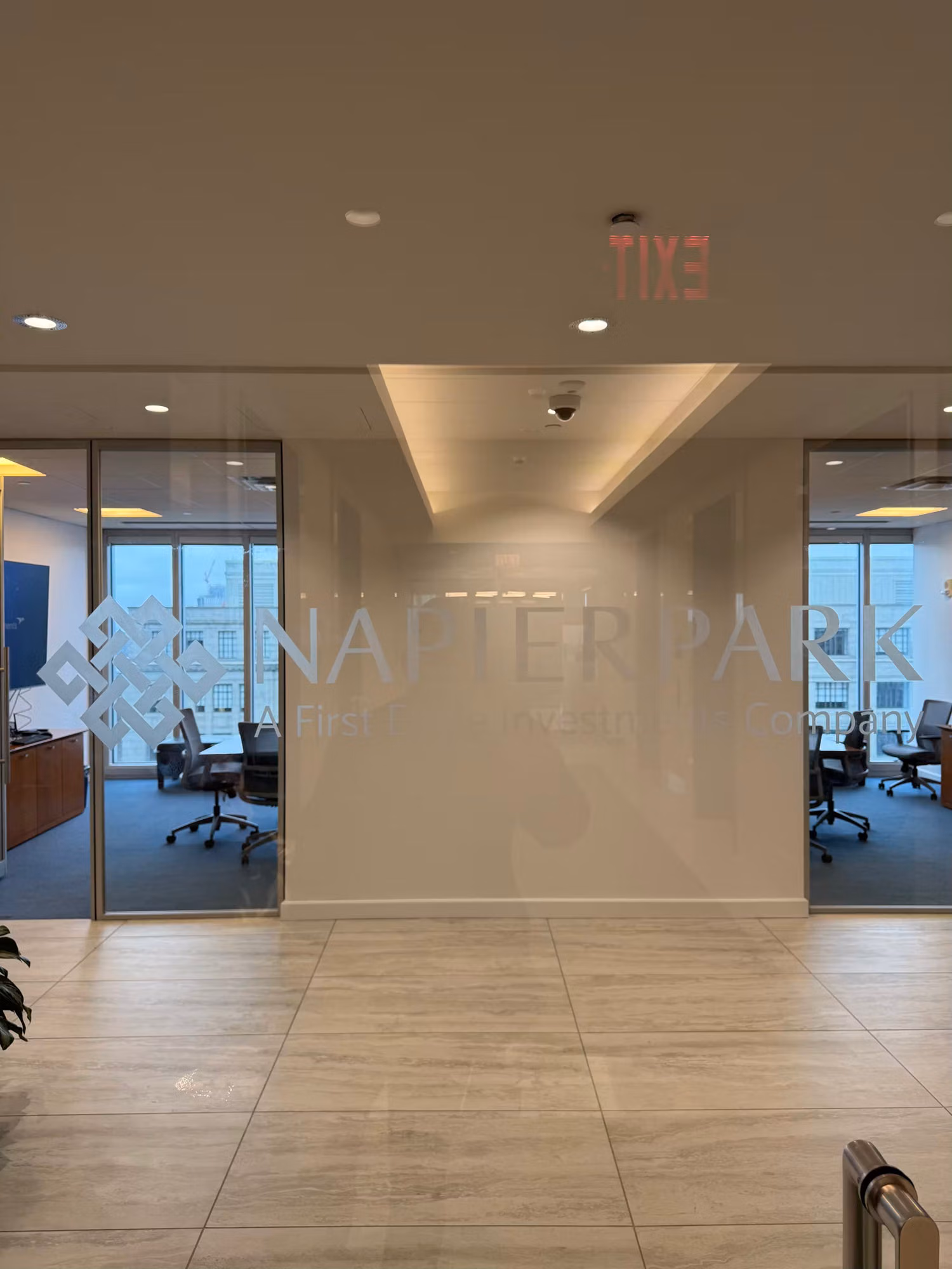 Frosted reception feature wall with etched logo lettering between glass office partitions and view windows.