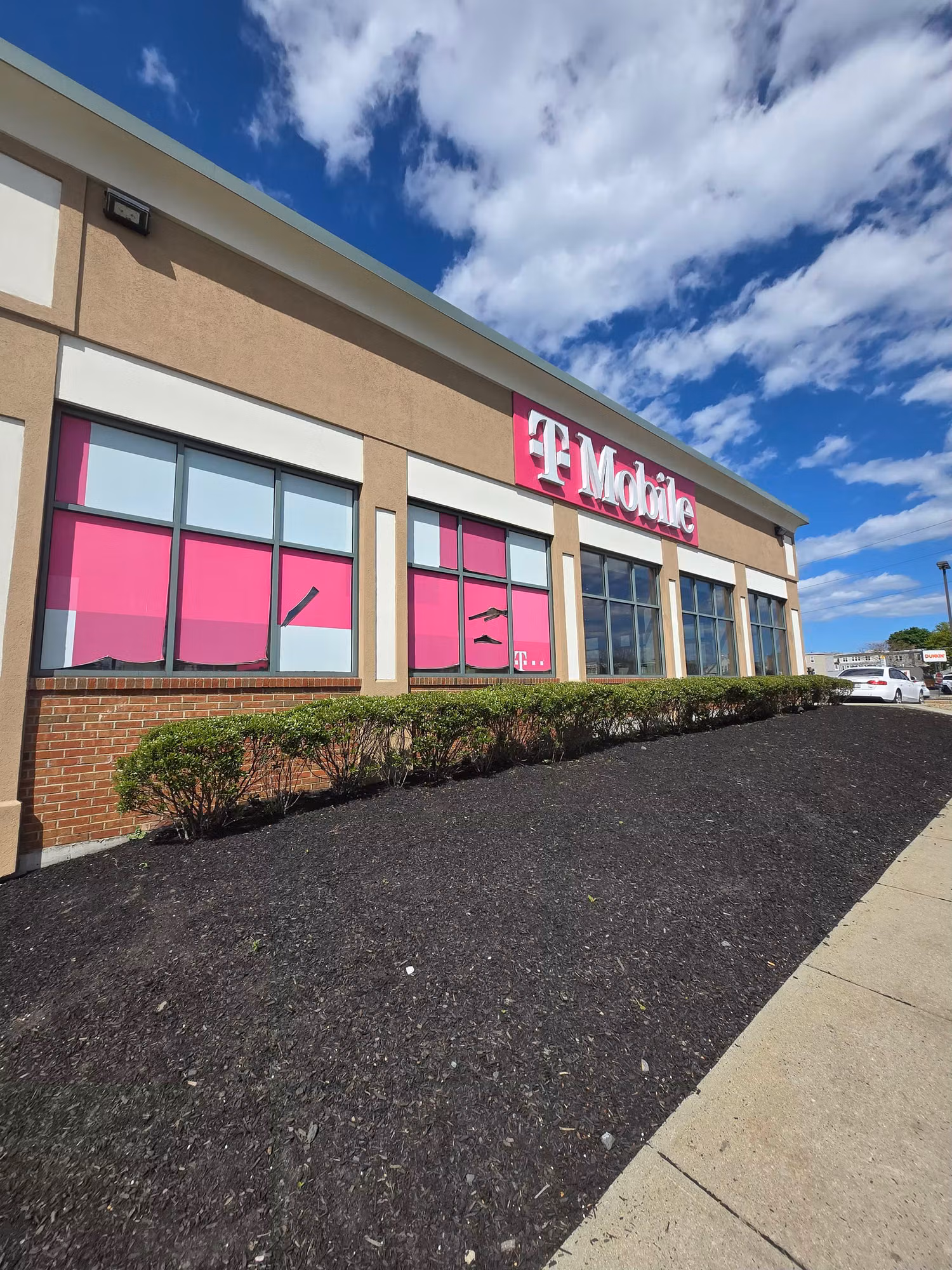 Side view of a retail storefront with bands of glass windows treated with commercial window film.