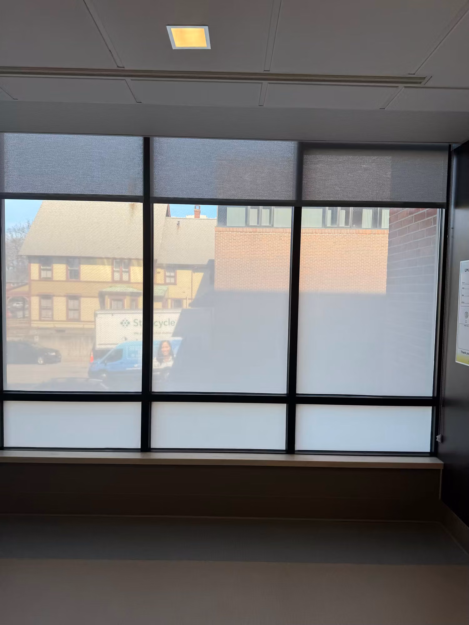Office window wall with translucent frosted privacy bands on the top and bottom panels and a clear middle section.