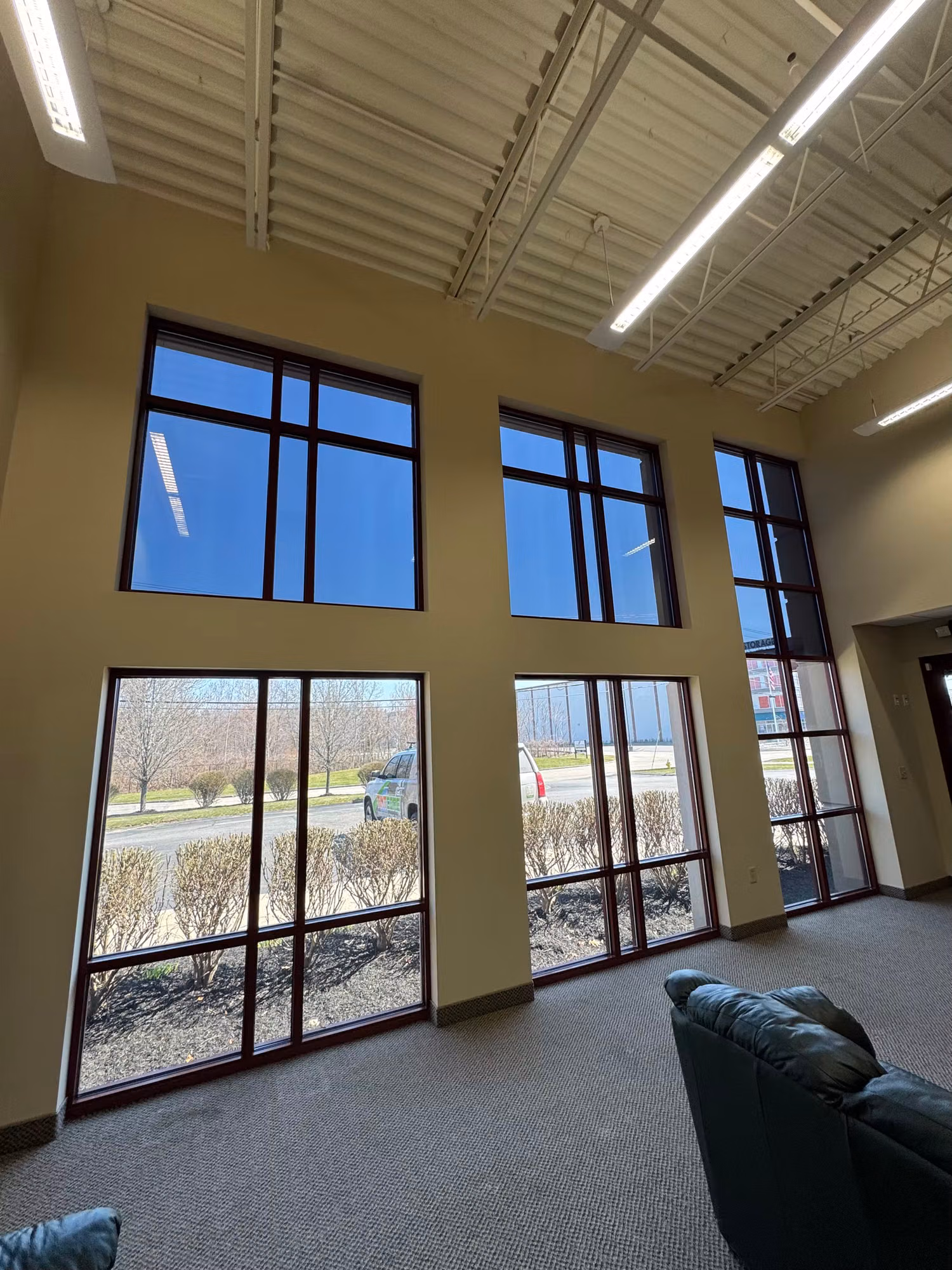 Two-story commercial lounge with floor-to-ceiling windows treated with film to cut heat and glare.