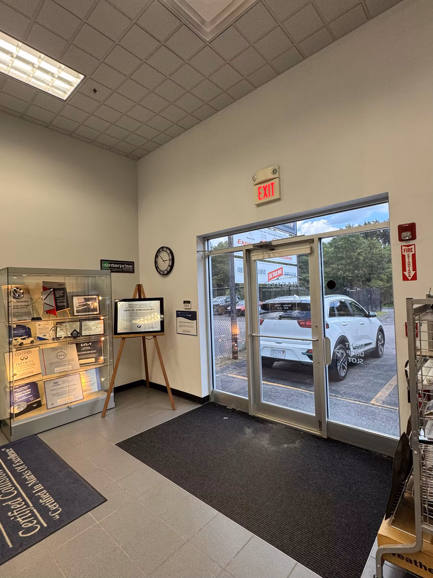 Commercial lobby looking toward tinted glass entry doors that cut glare from the sunny parking lot outside.