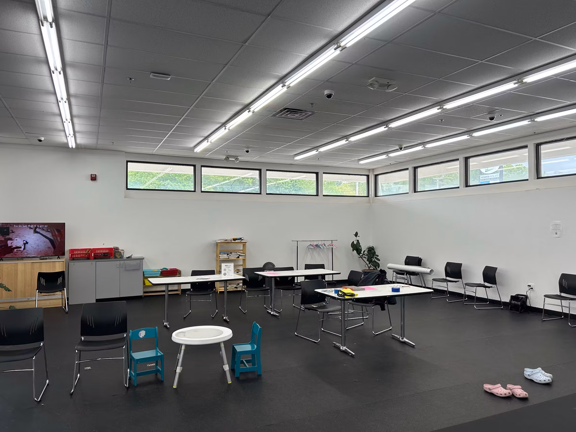 Multipurpose room interior with a band of high clerestory transom windows above the seating and tables.