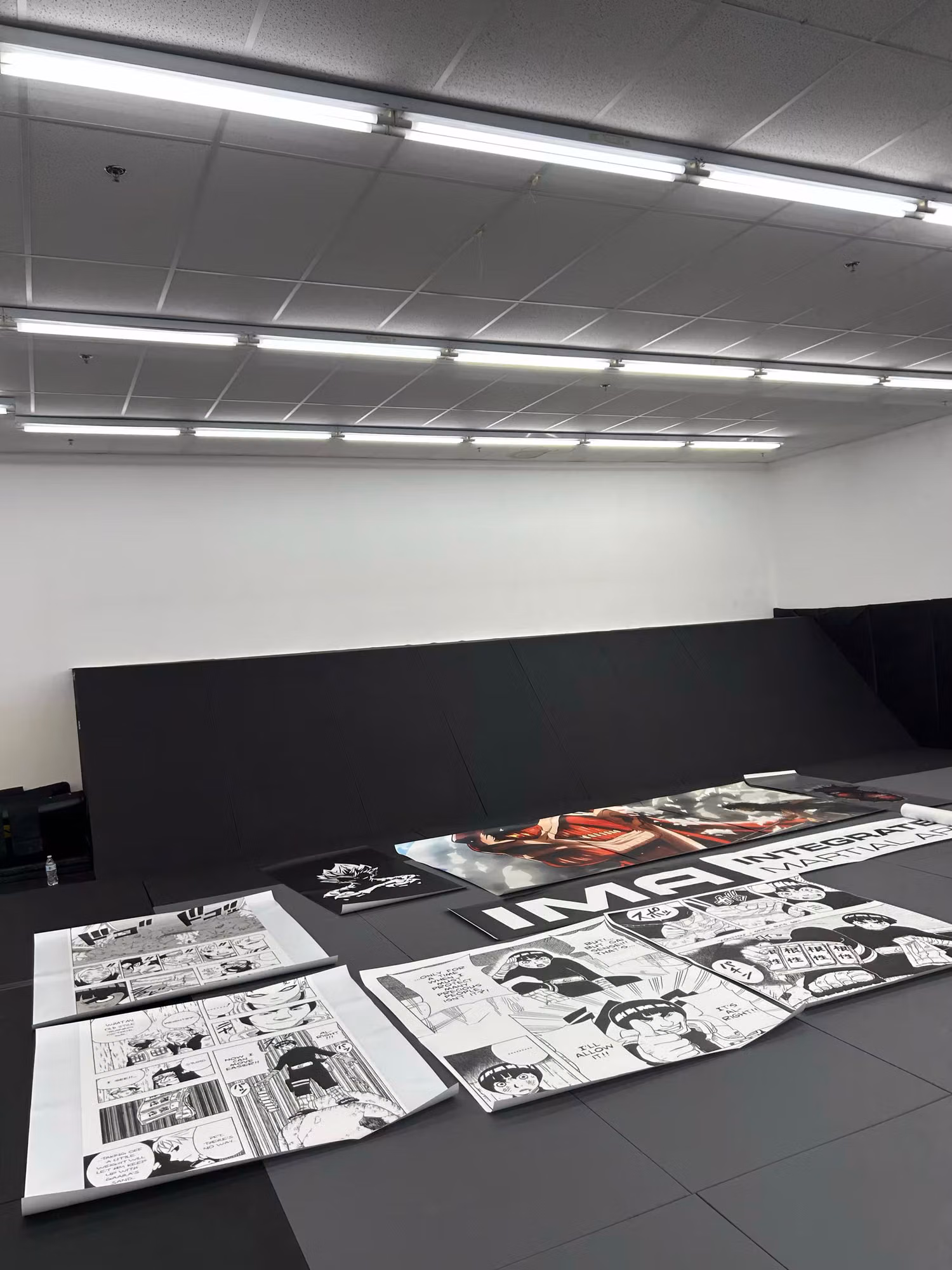 Large printed wall-wrap graphic panels laid out flat on a gym floor before installation onto the walls.