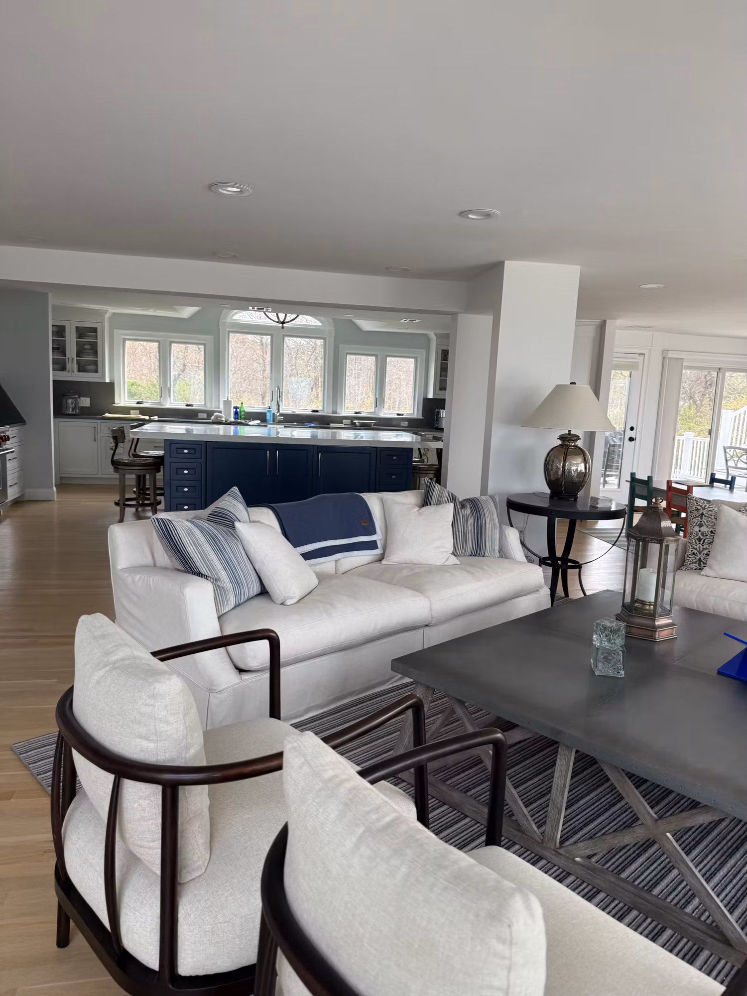 Bright living room and kitchen with multiple windows and a glass door carrying clear window film.