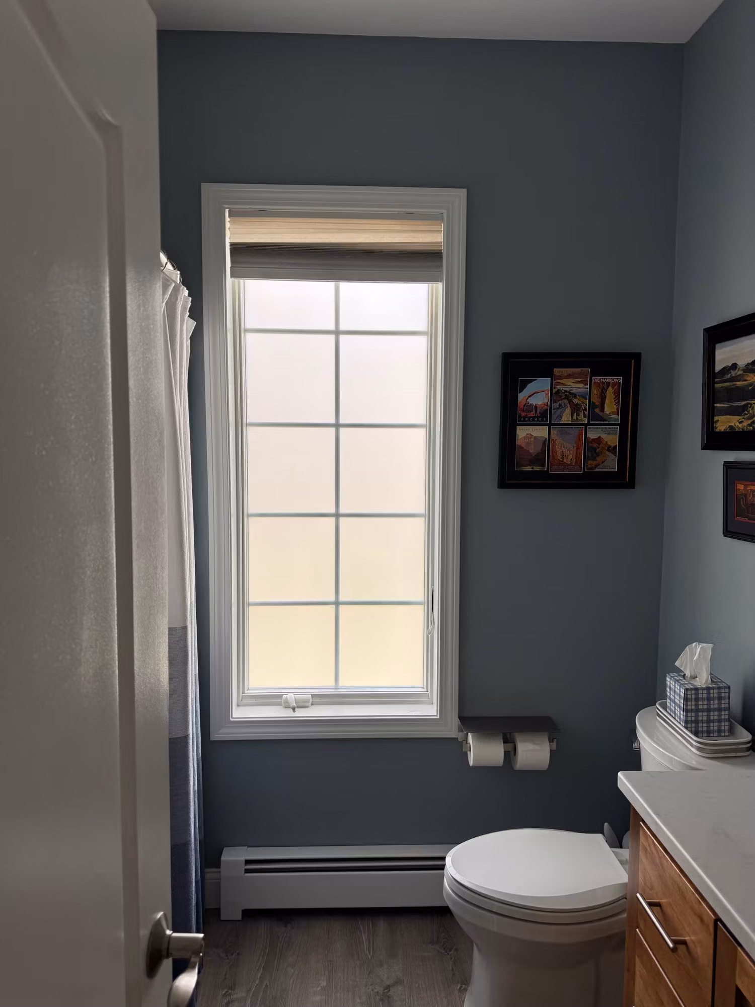 Bathroom window covered with frosted privacy film, diffusing light while fully obscuring the view through the glass.