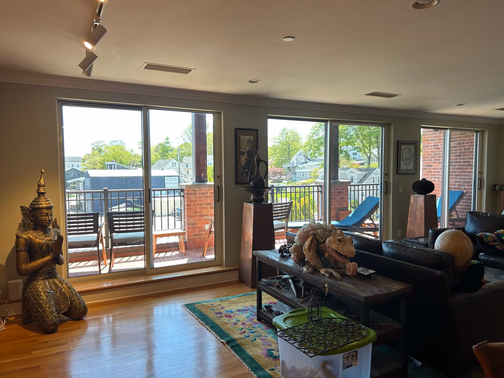 Living room with two large sliding glass balcony doors and window film overlooking a harbor view.