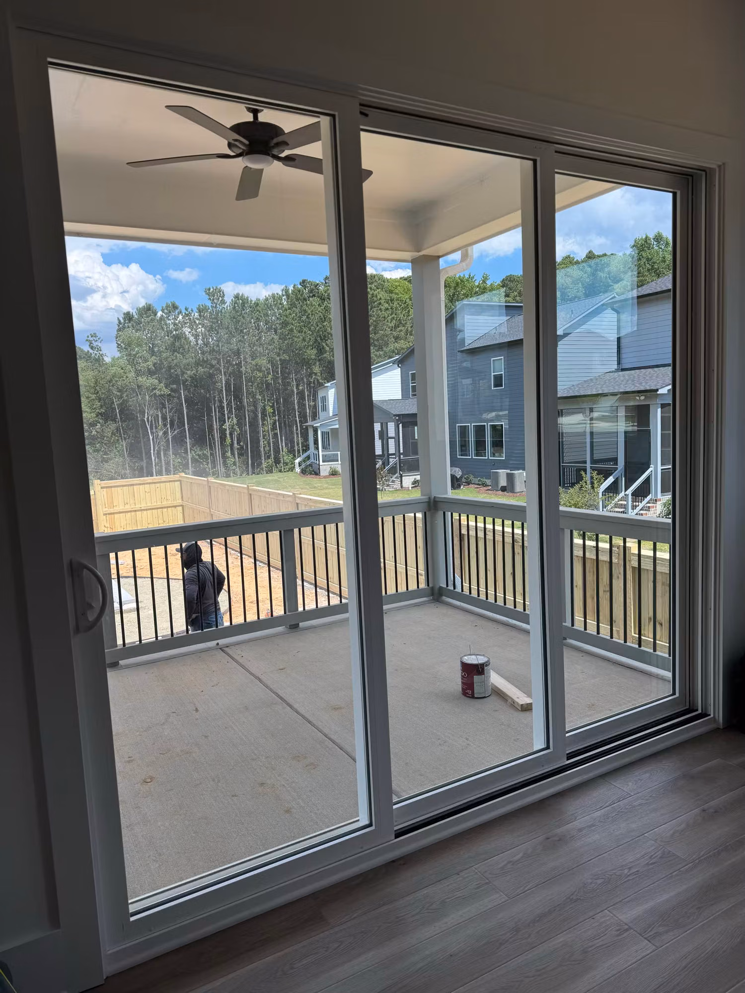 Sliding glass patio doors with window film opening onto a covered porch and fenced backyard.