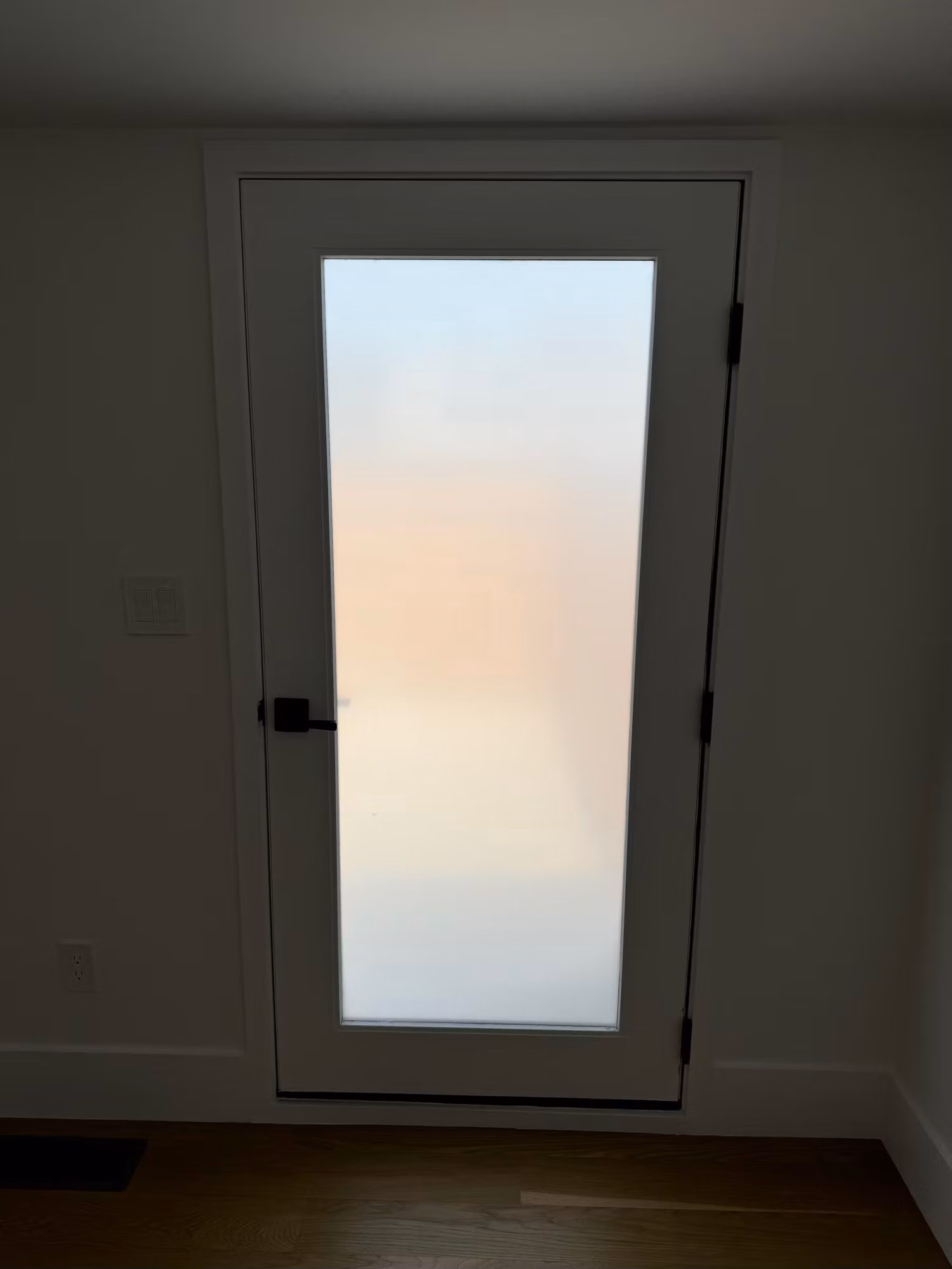 Full-lite entry door glass panel finished with white frosted privacy film for daytime privacy.