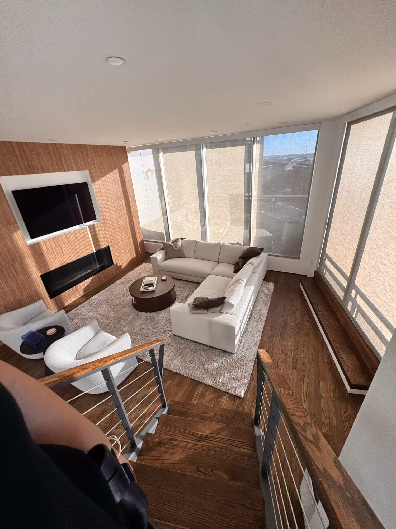 Living room with floor-to-ceiling corner windows and solar control film keeping daylight and views intact.