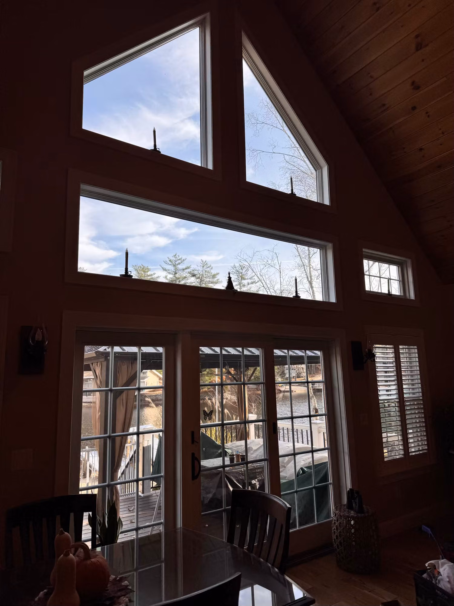 Vaulted dining area with tall gable windows and French doors fitted with window film over the deck view.