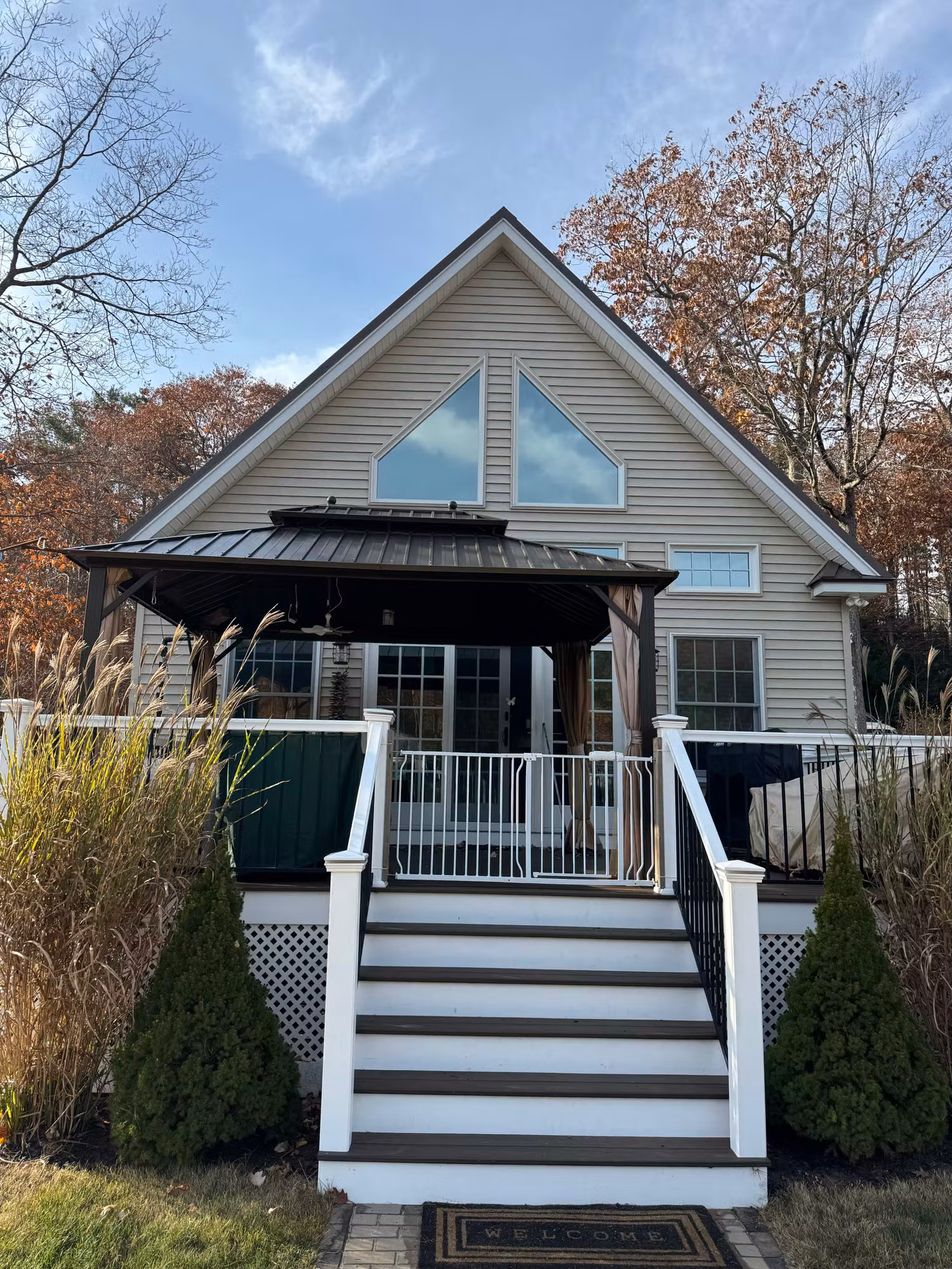 Exterior of a sided home showing the front gable window and covered porch where window film was installed.